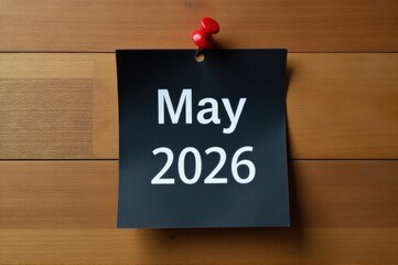 A note stuck to a wooden wall with a red push pin, providing a subtle pop of color..New Year 2026.