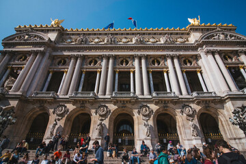 Fototapeta premium Crowd Enjoying The Sunny Weather Sitting On The Stairs Of The Opera Garnier In Paris, France
