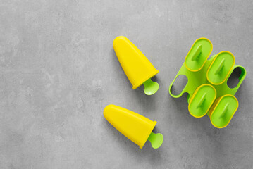 Colorful molds for homemade popsicles and ice cream on a concrete background