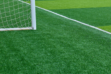 Close up of a soccer goalpost on a vibrant artificial grass playing field