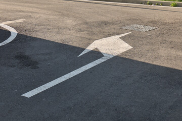 Parking lot arrow indicating direction on asphalt surface