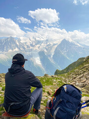 Hiker Admiring Panoramic Alpine View in the Mountains, Glacier View. Tour du Mont Blanc. Vertical. 
