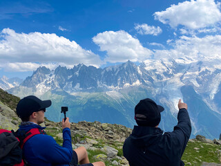 Hikers Capturing and Admiring Alpine Peaks in the French Alps. View of Mountains and Glacier. Tour du Mont Blanc (TMB).