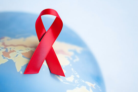 Global awareness symbol: Red ribbon on a world map. Showing global effort and hope for the future, health, and global awareness.