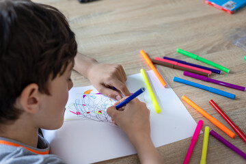 Child draws fractal patterns with crayons as part of art therapy. Creative activity for emotional...