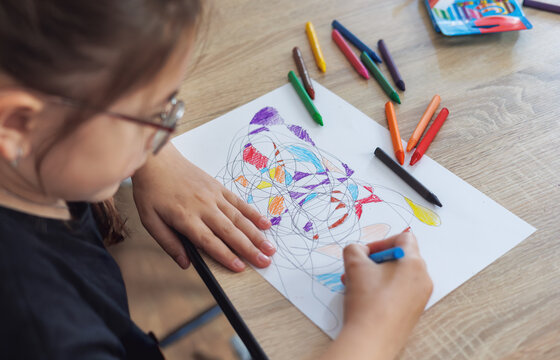 Child draws fractal patterns with crayons as part of art therapy. Creative activity for emotional well-being, mindfulness, stress relief, neurography, mental health support for kids. Copyspace