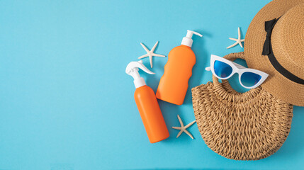 Orange sunscreen, sunglasses, straw hat, beach bag, sea stars on blue background. Summer vacation and skin care concept, cosmetics with SPF protection. Safe tanning concept on the beach