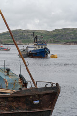 Rusty fishing boats and sunken shipwrecks in the famous ship graveyard of Teriberka under overcast...