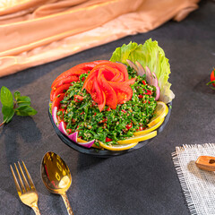 Fresh tabbouleh salad with parsley, tomatoes, and bulgur, garnished with lemon wedges. A vibrant...