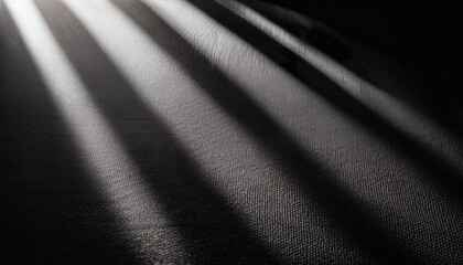 Fototapeta premium soft light casting horizontal rounded shadows on a textured black paper surface the abstract pattern resembles sunlight filtered through blinds or slats creating a calm modern aesthetic