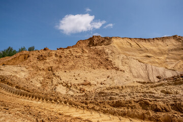 Sand against the blue sky. Sand quarry, sand mining, development