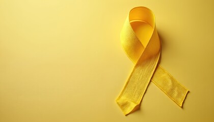 Yellow ribbon on yellow background. Concept for awareness, support of various health issues like endometriosis, microencephaly suicide prevention. Ribbon bow satin fabric texture. Copy space for text
