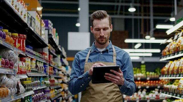 Man employee checking inventory stock in supermarket using tablet for product management system data - Powered by Adobe