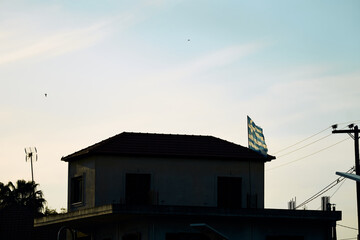 Windy afternoon in the Alps with a mountain-top house and flags fluttering in the breeze