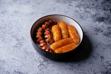 Fototapeta premium Fried sausages with spicy tomato sauce teokbokki, tokpokki in a bowl