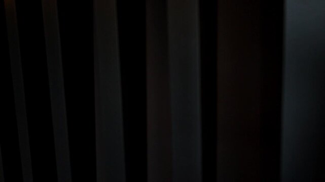 Parallel vertical lines sliding horizontally create a mysterious dark background