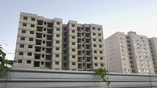 Contrast Between Unfinished Building and Occupied Residential Tower