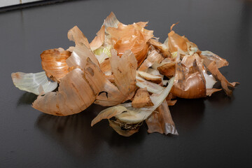 Onion peel isolated on black table.Close up of scattered dry onion peel as background.Close up view...