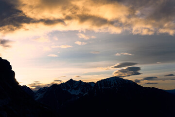 Majestic sunset over the snow-capped peaks of the Alps illuminating the rugged landscape