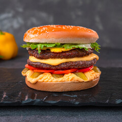 Juicy Cheeseburger with Lettuce and Tomato on Black Background
