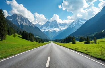 Fototapeta premium Open road stretches towards majestic Swiss Alps under cloudy blue sky. Asphalt road surrounded by green meadows, forests. Travel, vacation, road trip through picturesque landscape, freedom,