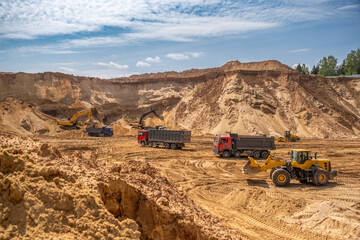 From afar - the work of a sand quarry. There is a lot of equipment, the development of minerals is...