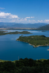 Obraz premium Türkisblauer See mit kleinen stark bewachsenen Inseln mitten in Montenegro, Slano Jezero