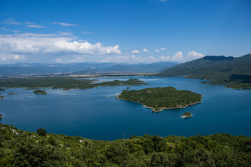 Naklejka premium Türkisblauer See mit kleinen stark bewachsenen Inseln mitten in Montenegro, Slano Jezero