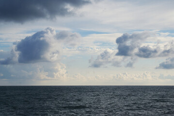 Sunset over sea, sun glare on water and clouds, background