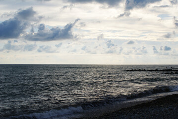 Sunset over sea, sun glare on water and clouds, background