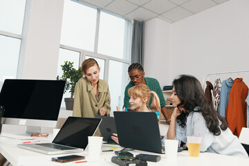 Young adult coworkers socializing and working together in a bright workplace, showcasing business...