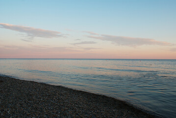 Sunset over sea, sun glare on water and clouds, background