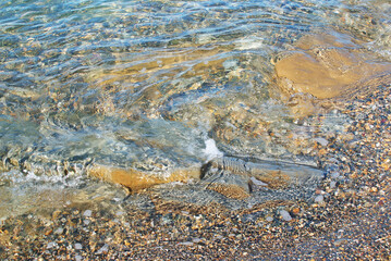 Stones in the sea and on the bottom of the sea, sun glare on water, underwater world, background