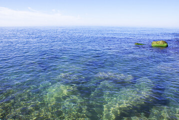 Beautiful sky above the sea, rocky seashore, pebbles on the sea bottom, nature.
