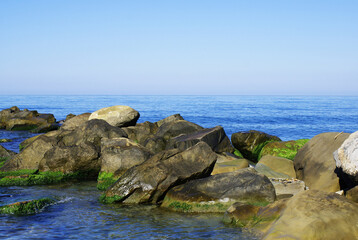 Beautiful sky above the sea, rocky seashore, pebbles on the sea bottom, nature.