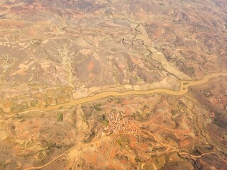 aerial view of a river meandering through the arid, parched terrain of madagascar, showcasing the...