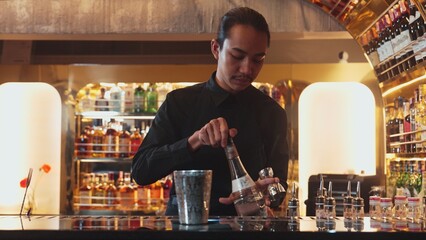 Asian bartender pouring mixed cocktail juice liqueur all ingredient into sliver shaker alcohol...