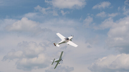 two light aircraft perform aerobatics, coming dangerously close to each other at minimum altitude