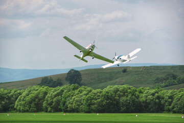two light aircraft perform aerobatics, coming dangerously close to each other at minimum altitude