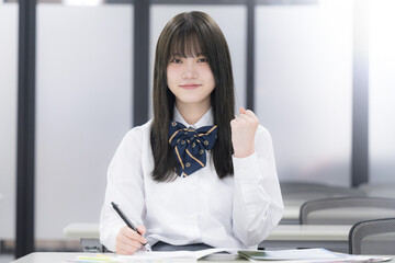 学校や塾の授業中に勉強する女子高校生 カメラ目線　ガッツポーズ
