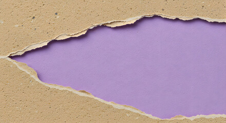 Torn textured cardboard reveals a vibrant violet background creating an abstract, artistic and colorful pattern, offering unique visual interest.