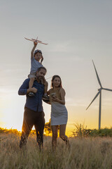 Family with son walking on field on wind farm. Happy Family and son playing at the Wind turbines...