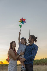 Family with son walking on field on wind farm. Happy Family and son playing at the Wind turbines...