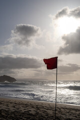 Red warning flag on windy beach