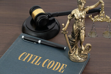 A gavel, Lady Justice, and a book titled Civil Code, symbolizing the authority of law, justice, and...