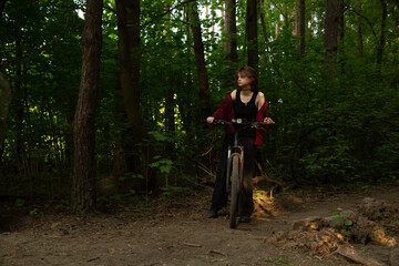 Beauty woman biking on bicycle on spring trees green forest background, looks happy. Fun sport girl...