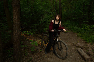 Beauty woman biking on bicycle on spring trees green forest background, looks happy. Fun sport girl...