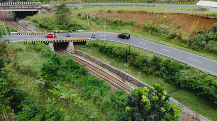 Aerial view of road overpass crossing railway track in rural Indonesia. A scenic infrastructure...