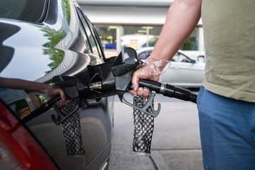 Man driver hand refilling the car with fuel at the gas petrol station. 