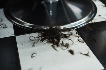 Hair clippings scattered on a checkerboard floor after a fresh haircut